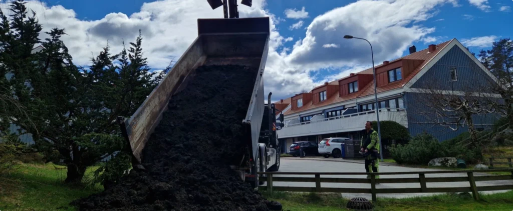 Lastbilen tippar jord vid radhusen